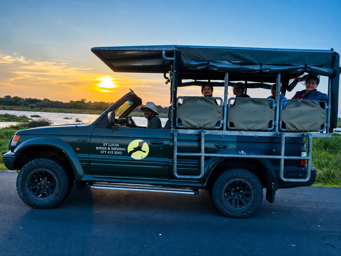 Open birding safari vehicle with guests at sunset beside wetlands